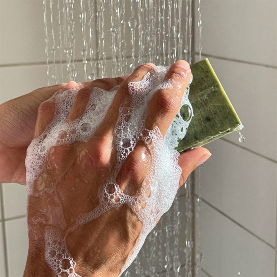 Tealu tea tree soap bar lathering in a pair of wet hands